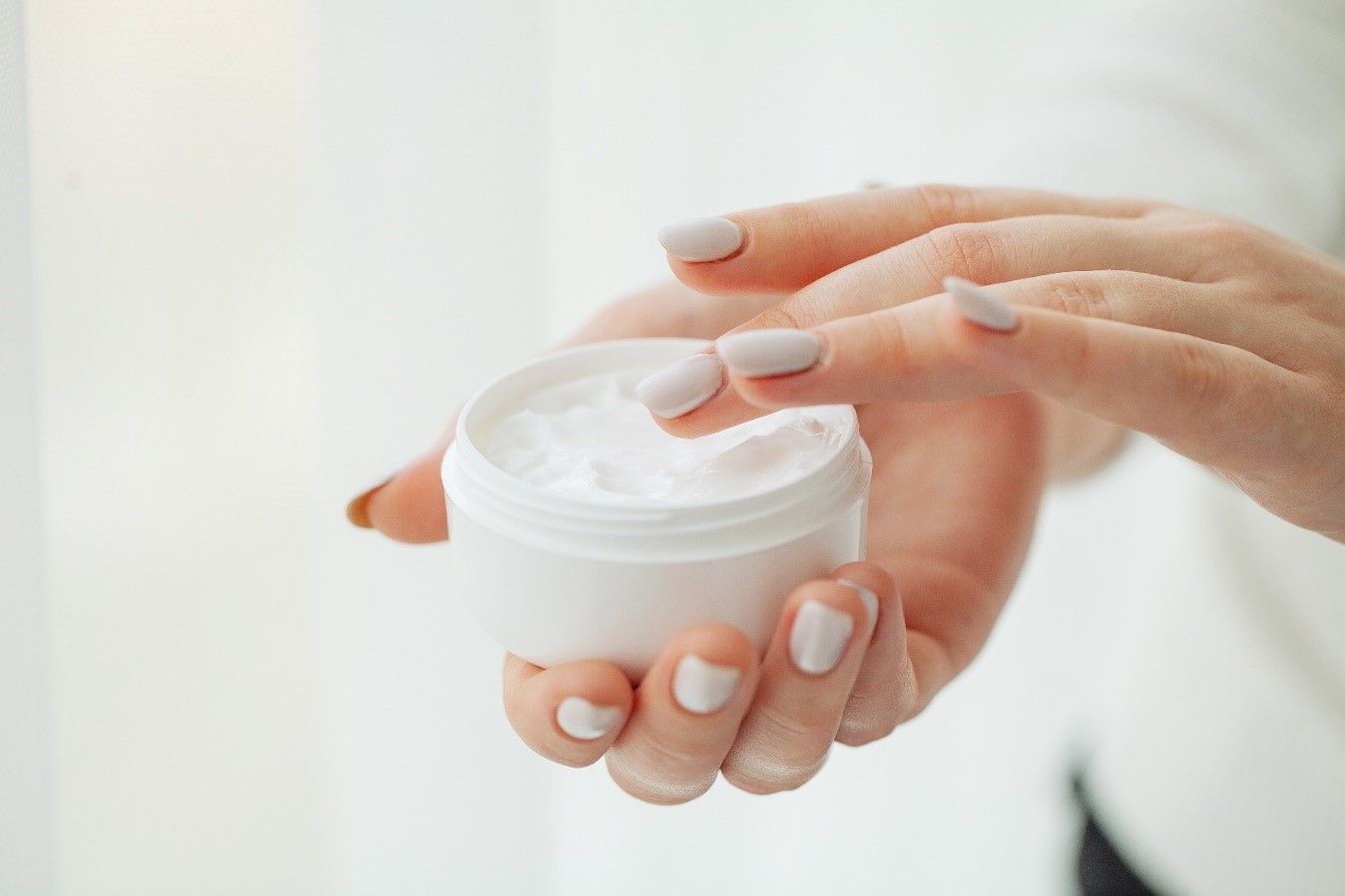 Woman applies a healthy cosmeceutical skincare product