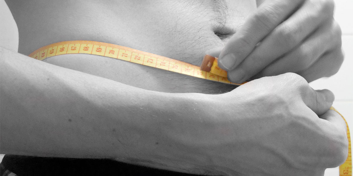 Image credit: Adrian Clark close up image of a man measuring his torso with a measuring tape